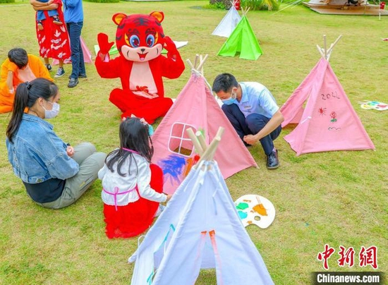 春节假期，天涯海角景区员工与游客互动。　景区供图